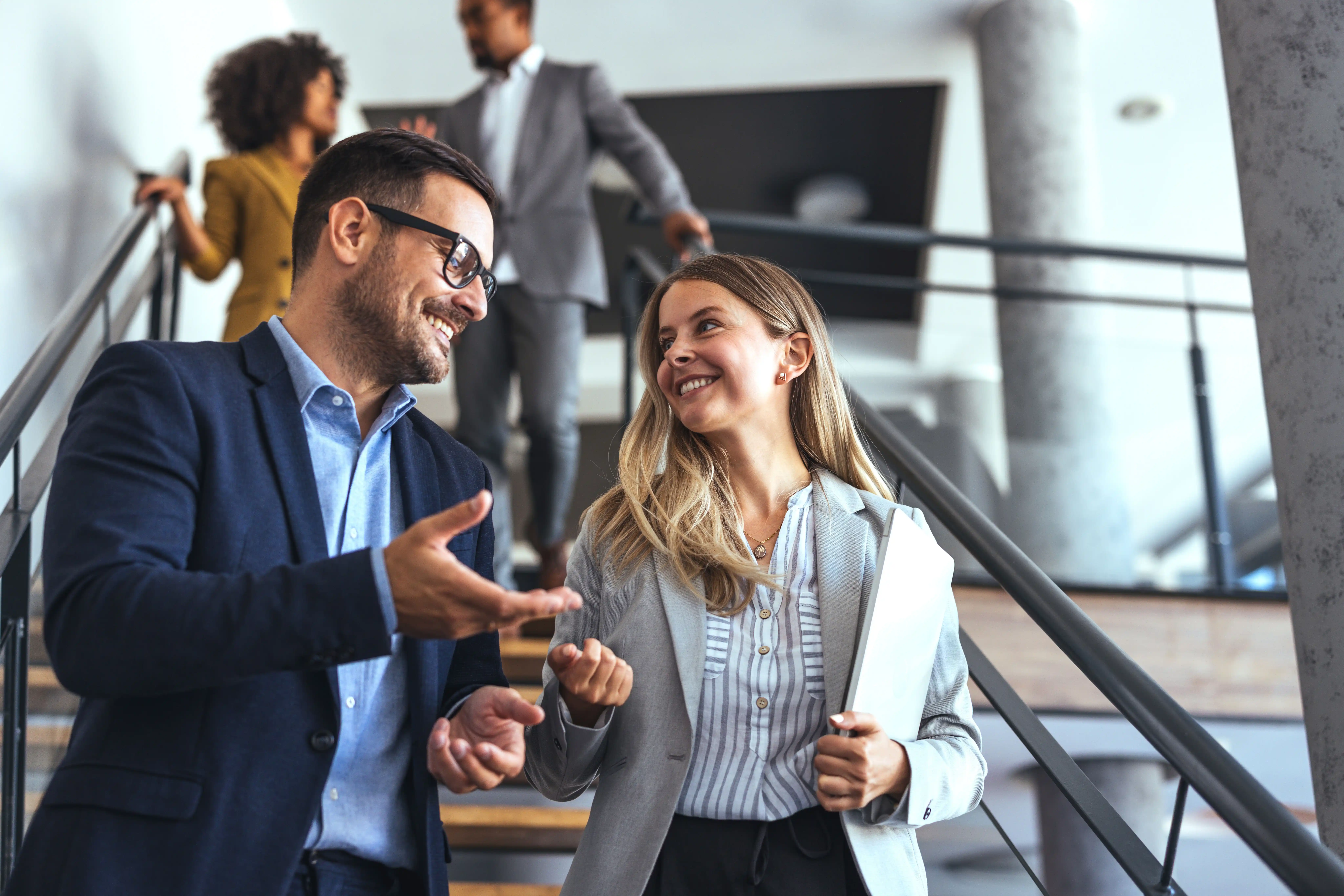 a man and woman talking on the stairs in a financial office