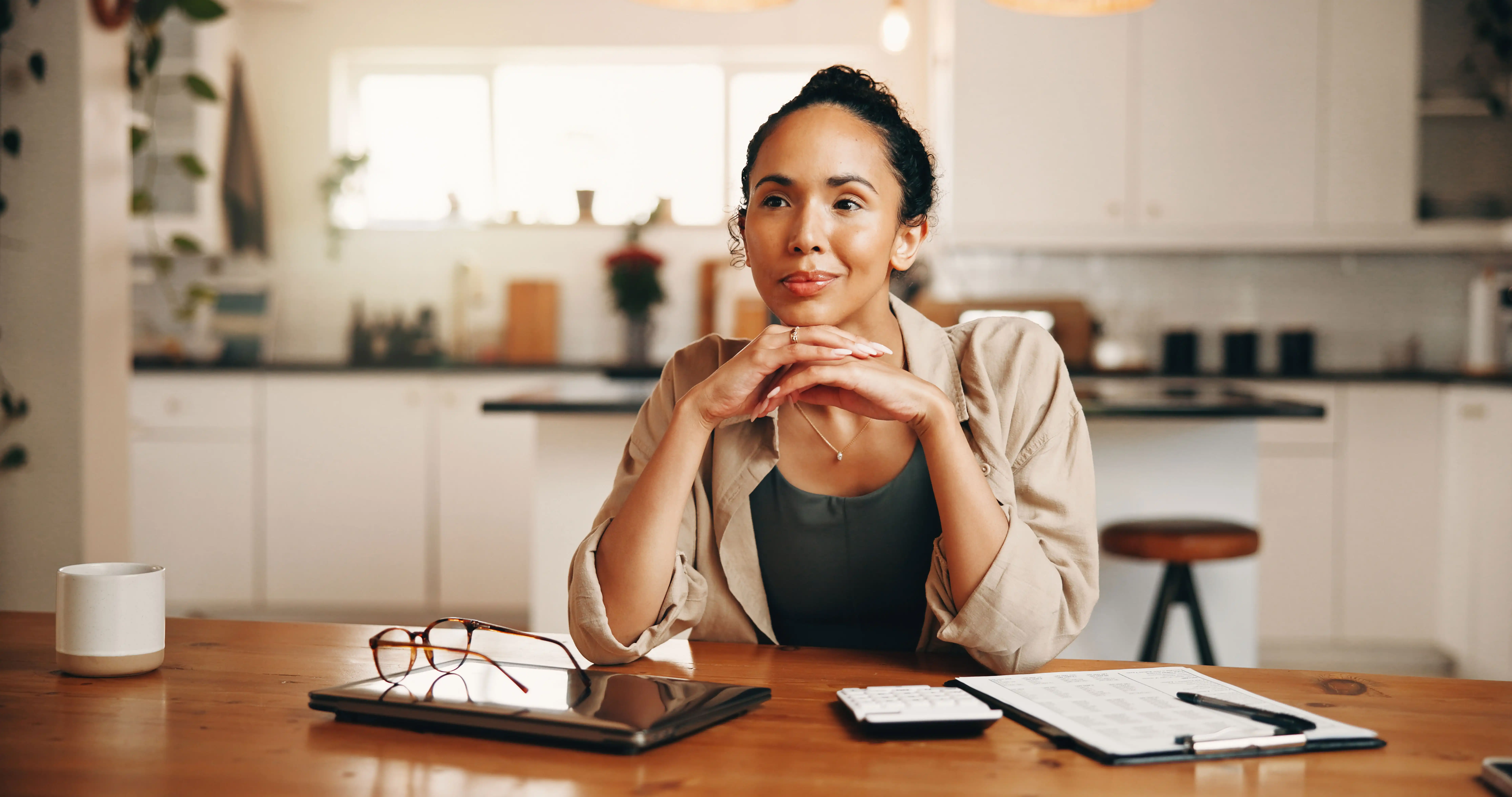 woman at kitchen table thinking about her finances